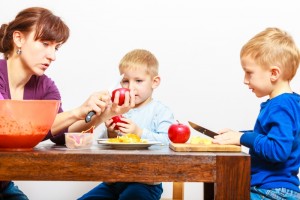 11899437-mother-with-sons-cutting-fruits-apples-at-home